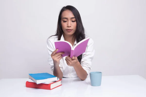 Jonge Aziatische vrouw lezen een boek met kopje koffie. — Stockfoto