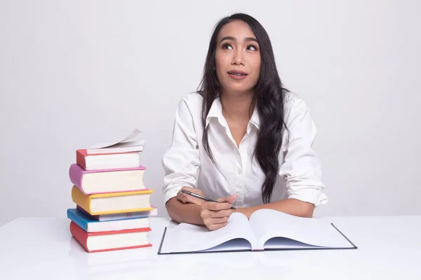 Joven mujer asiática leer un libro con libros en la mesa . — Foto de Stock