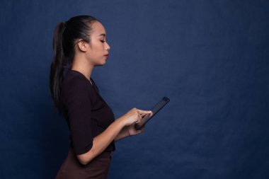 Bir bilgisayar tablet ile genç Asyalı kadın.