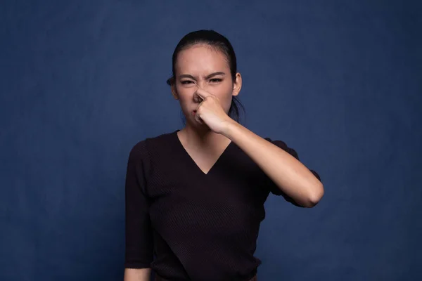 Giovane donna asiatica tenendo il naso a causa di un cattivo odore . — Foto Stock