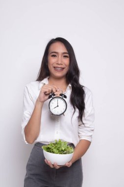 Saat ve salata ile genç Asyalı kadın.