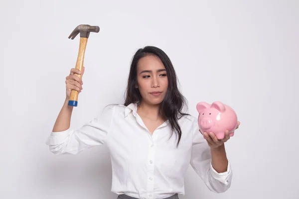 Asian woman with pig coin bank and hammer. — Stock Photo, Image