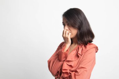 Unsure hesitant nervous young asian  woman biting her fingernails on white background clipart