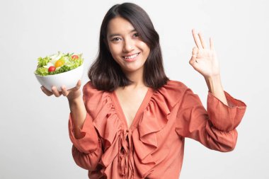 Sağlıklı Asyalı kadın beyaz zemin üzerine salata ile Tamam göster