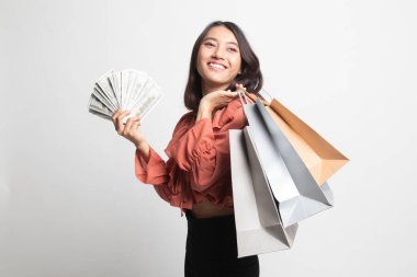 Asyalı genç bir kadının portresi beyaz arka planda bir sürü para banknotu gösteriyor.