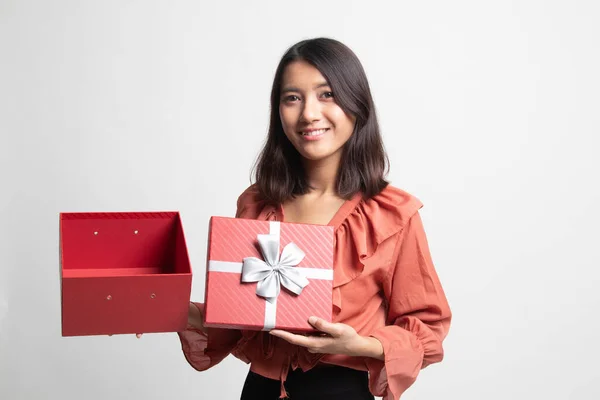 年轻的亚裔女子打开白色背景上的金色礼盒 — 图库照片