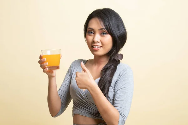 Ung Asiatisk Kvinna Tummen Upp Dricka Apelsinjuice Beige Bakgrund — Stockfoto