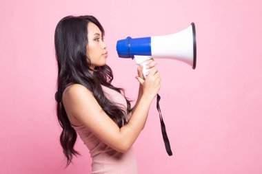 Güzel genç Asyalı kadın pembe arka planda megafonla anons yapıyor.
