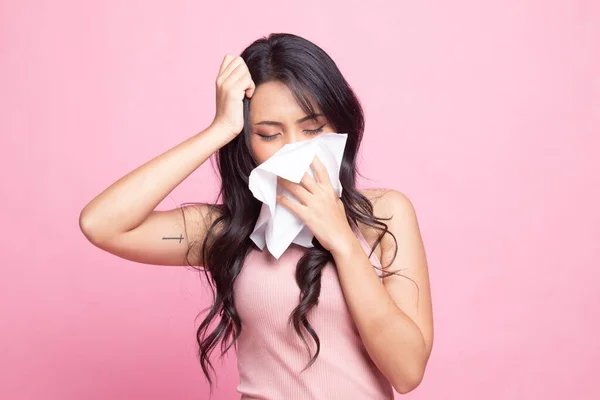 Young Asian woman got sick and flu on pink background