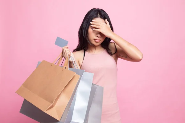 幸せな若いですアジアの女性でショッピングバッグやクレジットカードでピンクの背景 — ストック写真