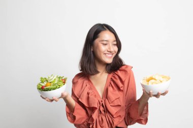 Patates cipsi ve beyaz zemin üzerine salata ile genç Asyalı kadın