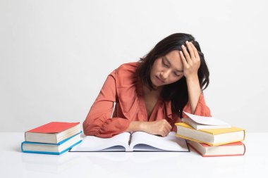 Yorgun Genç Asyalı kadın tablo kitapları ile beyaz arka plan üzerine bir kitap okumak