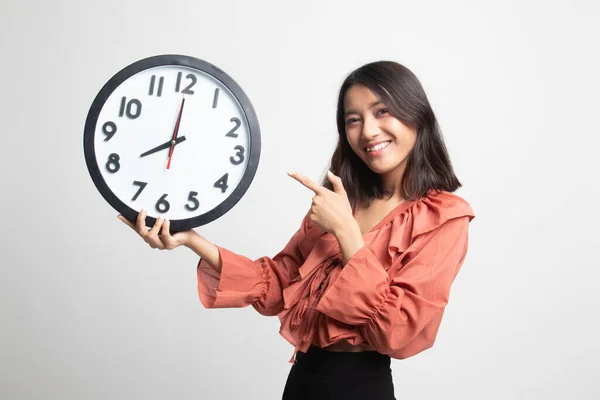 Junge Asiatische Frau Zeigt Auf Eine Uhr Auf Weißem Hintergrund — Stockfoto