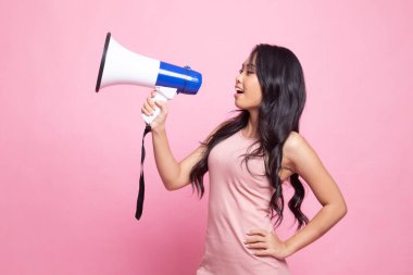 Güzel genç Asyalı kadın pembe arka planda megafonla anons yapıyor.