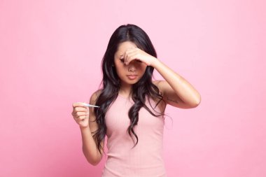 Genç Asyalı kadın hastalandı ve pembe arka planda grip.