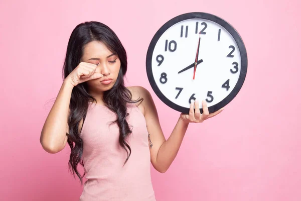 睡梦中的年轻亚洲女人 早上带着一只粉红背景的钟 — 图库照片