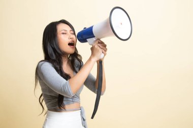 Güzel genç Asyalı kadın bej arka planda megafonla anons yapıyor.