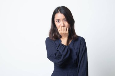 Tereddütlü genç Asyalı kadın beyaz arka planda tırnaklarını yiyor.