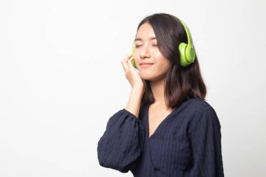 Güzel Asyalı kız beyaz arka planda kulaklıklarıyla müzik dinliyor.