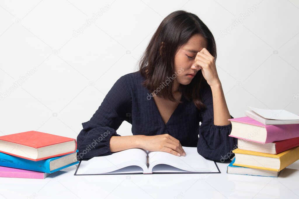 Exhausted Asian woman got headache read a book with books on table on white background