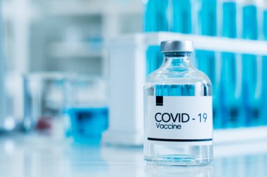 Arka plandaki Covid-19 aşısı Coronavirus 2019 konseptine dayanan bir bilim laboratuvarı..