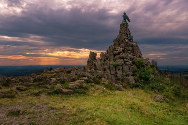 Havacı bulutlu günbatımı gökyüzünün altında dağda bir dönüm noktası.