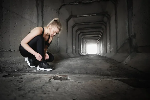 Woman lacing running shoes before workout.