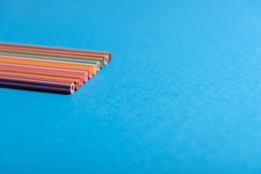 Sol tarafta hala gökkuşağı kalemlerinin dar derinliği mavi arkaplan üzerinde