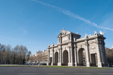 Puerta de Alcala anıtı. Güneşli bir kış sabahında uçak izleriyle birlikte anıt inşa ediliyor.