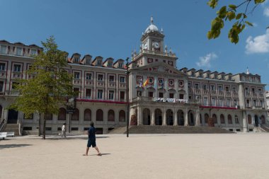 Ferrol / Galiza / İspanya - 08 08 08 2020: Yazın güneşli bir öğleden sonrasında bilinmeyen bir adam Ferrol belediyesinin önünden geçiyor. Yeniden tasarlandıktan sonra yepyeni bir ana kare görüntüsü, 2020 'de tamamlandı. Yerel, seyahat, siyaset ve bayram bilgileri için çok amaçlı resim