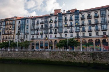 Bilbao, Euskal Herria, İspanya - 09 04 04 2018: Ibaiondo Mahallesi ve Nervion Nehri 'nin Bilbao şehri yaz günbatımında mavi gökyüzü ve bulutlarla. San Frantzisko ve Martzana bölgesi seçiliyor