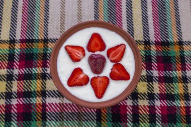 Çilek dilimlenmiş ve güzel düzenlenmiş bir kase yoğurt.