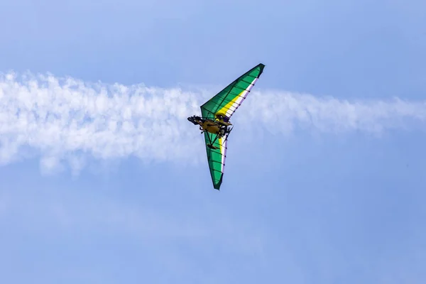 Motorized deltaplan flying in the air with beautiful blue sky on the background