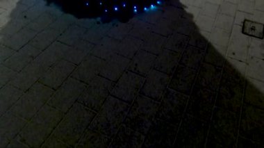 Bir Noel ağacı ve binalar arasında bir sokakta asılı ışıklar ortaya