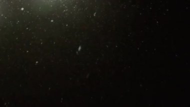 Ağır çekim bir sokak lambasının aydınlatılmış bir düşen kar