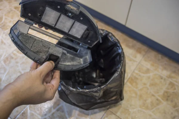 Vaciar el cubo de basura de una aspiradora robot — Foto de Stock