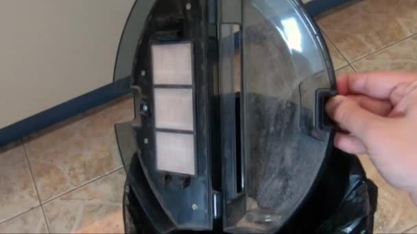 Cleaning the dust bin of a robot vacuum cleaner — Stock Video