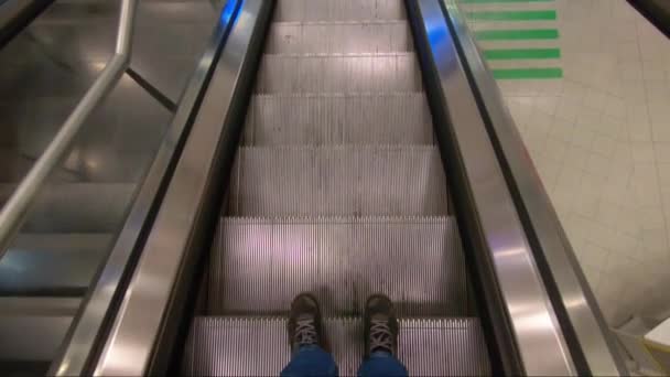 Standing on a escalator looking down to hes feet — Stock Video