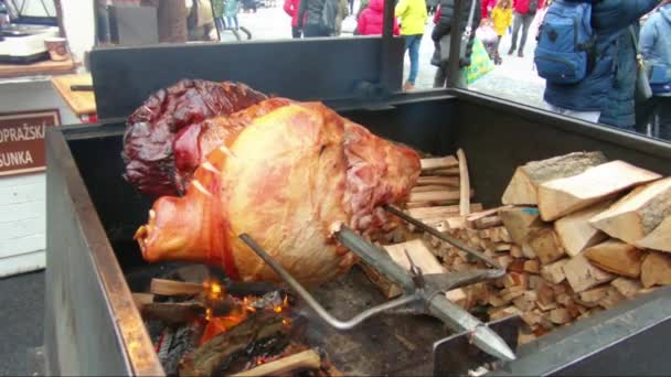 Deliciosos trozos de jamón prague escupen asando en un mercado callejero — Vídeo de stock