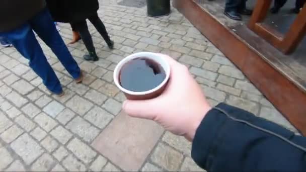 Man holding a cup of mulled wine at the market — Stock Video