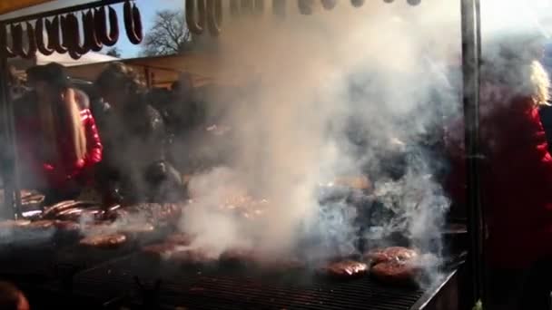 Rauchwolke über einem großen Grill mit Brot und Würstchen — Stockvideo