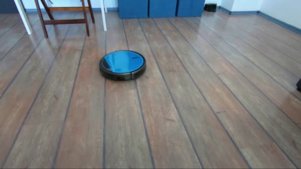 Person som kopplar av på en soffa med robot vacuum fjärrkontroll i hand — Stockvideo