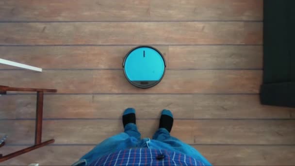 Persona de pie con robot de vacío inteligente de control de aplicaciones — Vídeo de stock