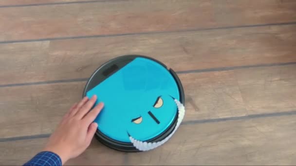 Adam gözler ve gülümseme ile bir robot elektrikli süpürge Evcil hayvan çiftliği — Stok video