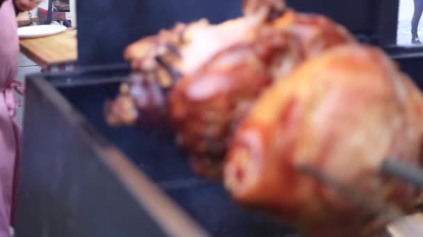 Deliciosos trozos de jamón prague escupen asando en un mercado callejero — Vídeo de stock