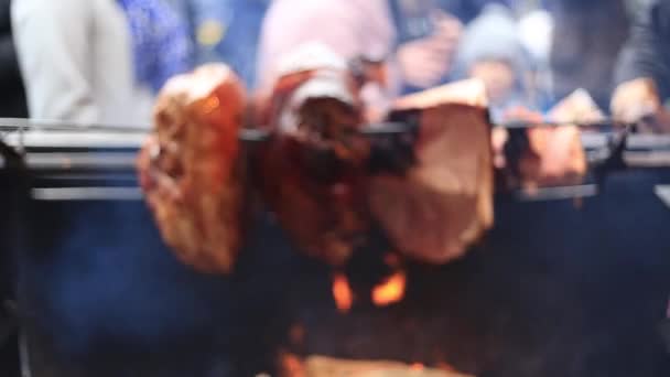 Deliciosos trozos de jamón prague escupen asando en un mercado callejero — Vídeos de Stock