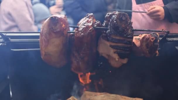Deliciosos trozos de jamón prague escupen asando en un mercado callejero — Vídeos de Stock