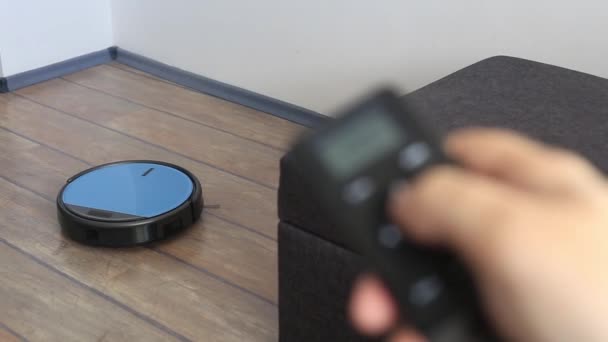 Člověk relaxovat na pohovce s dálkovým vakuum robot v ruce — Stock video