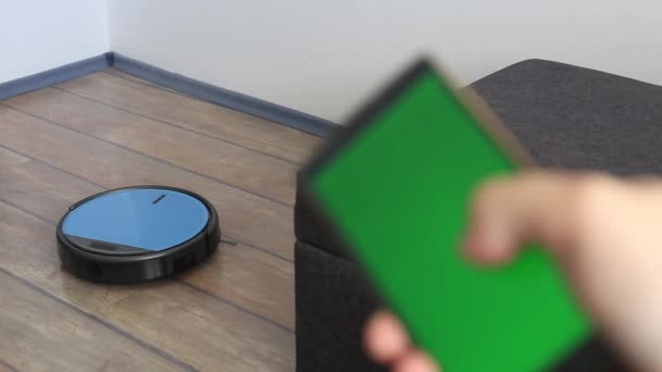 Person relaxing on a sofa with robot vacuum smart application control — Stock Video