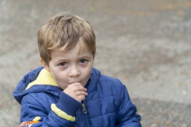 Parkta patlamış mısır yiyen küçük çocuk